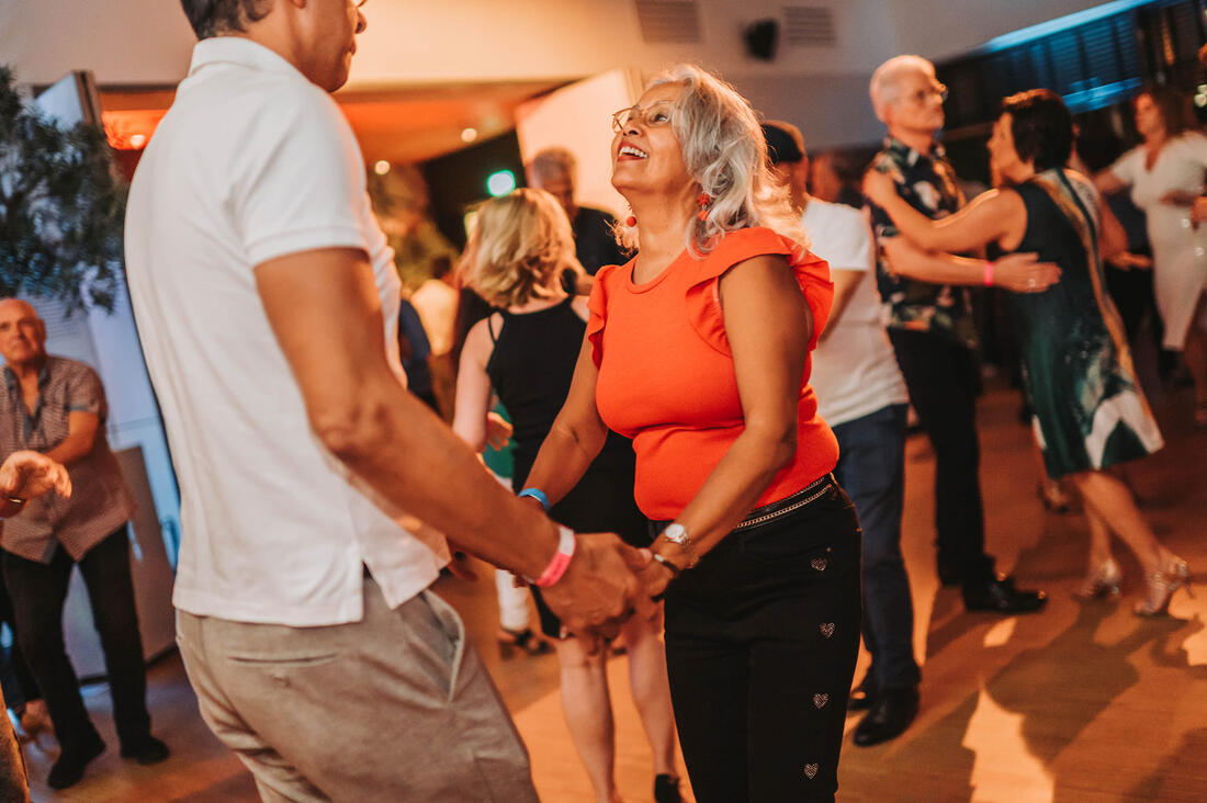 Dansende paren in een warme zaal