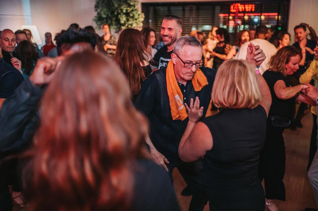 Dansers met geheven armen tijdens een feest
